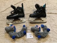 Pair of black Bauer child hockey skates with horse-shaped plush blade guards, shown side by side on carpeted floor