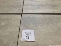 Close-up photo of four laminate tiles showing imitation soapstone pattern and embossed stone finish.