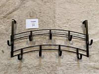 Two metal over the door hook racks with 4 hooks each, displayed on carpeted floor.