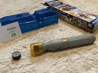 Photo of the Pedi Paws nail grinder and accessories along with product box on a carpet.