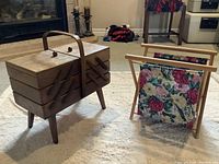 The two main items in the lot placed on carpet, showing the wooden sewing box with legs and the floral yardstick holder.