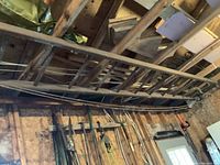 Full view of the wooden extension ladder mounted horizontally along a wall inside a workshop or garage.