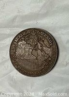 Reverse side of 1939 Canadian large commemorative coin showing map of Canada with provinces and Latin inscription with year 1939.