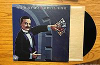 Front cover of Blue Oyster Cult album "Agents of Fortune" showing artwork of a tuxedoed man holding tarot cards in front of a mechanical lock.