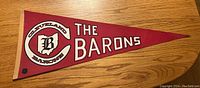Front side of the red felt pennant showing Cleveland Barons logo and text