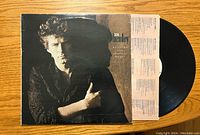 Front album cover with artistic portrait of Don Henley and partially visible black vinyl record and pink lyric insert