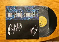 Front of album cover showing Fine Young Cannibals band name and stylized blue design with black and white band photo.