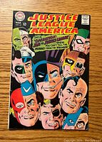 Front cover of the comic showing multiple Justice League members' faces close together, with the title and issue info visible.