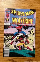 Front cover of the Spider-Man Versus Wolverine #1 comic book showing Spider-Man and Wolverine in combat with graveyard background.