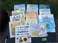 Photo showing 14 assorted children's books laid on grass including board books and paperbacks