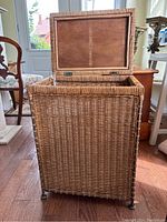 View of wicker laundry hamper with Lid open showing inside fabric liner and wooden lid underside