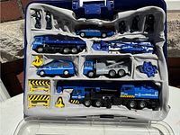 Top view of police vehicle playset neatly arranged in plastic molded tray inside carrying case showing vehicles, mini-figures, and accessories.