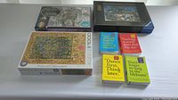 Photo showing two unopened puzzles, one 1000-piece Tree of Life tapestry puzzle, and four inspirational mini books with colorful covers