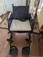 Front view of Drive wheelchair showing cushioned seat, padded armrests, and footrests.