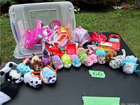 The first image shows the entire collection of 15 Zhu Zhu Pets with a variety of colors and fur designs, arranged on a black table with a clear plastic container in the background for storage. Several pink and red toy cars and play accessories are also visible.
