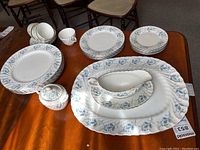 Overall display of various Aynsley Las Palmas 8274 dinnerware pieces on wooden table including plates, cups, sugar bowl, gravy boat and platter