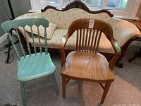 Both chairs together in front of a cream-colored sofa near window. Shows relative size and condition including finish wear.