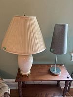 Two table lamps on a wooden table showing size and style difference