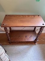 Top and angled view of rectangular wooden side table with turned legs and a lower shelf.