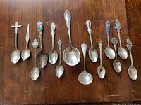 All 14 spoons and ladles arranged in a row on wood surface