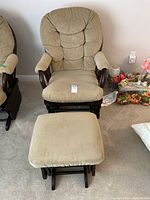 Full view of the glider rocker chair and matching ottoman, showing beige upholstery and wooden frames.