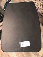 Top view showing black textured plastic tabletop with size sticker and Costco logo imprint.