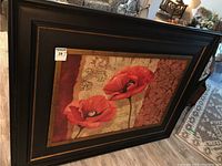 Framed art showing two vibrant red poppies with ornate background and dark frame