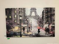 Wide shot of the large Paris street scene canvas showing the Eiffel Tower with pedestrians and umbrellas on a rainy day.