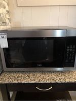 Front view of Whirlpool stainless steel microwave oven showing door and control panel.