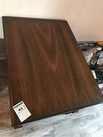 Top view showing the rectangular wood surface of the end table with medium brown finish and some wear.