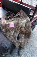 Camouflage neoprene hip waders with attached boots laid out, showing the full length and boot area.