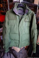 Front view of green Cloudveil men's down winter coat hanging on a hanger, showing full front, zipper and pocket details.