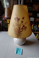 Full view of lamp showing tapered floral printed fabric shade and ceramic base.