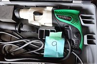 Rotary hammer drill in open case, showing body, power cord, and side handle