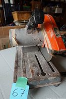 Side view of the Makita cut-off saw showing the entire base, blade guard, and handle with signs of rust and wear.
