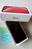 Red iPhone XR in original box showing screen and box top