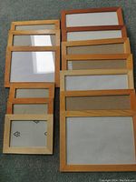 Overview of 10 new IKEA wood photo frames in various sizes and wood finishes, arranged in two rows