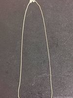 Full-length chain laid flat on black surface