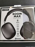 Front of box showing headphones behind plastic window, brand Fisher, model Boom Max wireless headphone, features including hands free microphone, dynamic sound, wireless streaming, long lasting battery and Bluetooth logo.