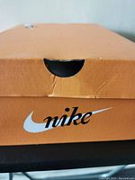 Orange Nike shoebox with Nike logo on side, showing some minor creasing.