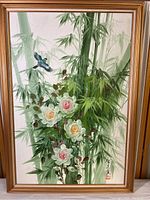 Full view of the framed painting showing bamboo, flowers, and a bird with signature and red seal.