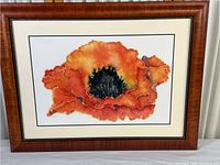 Full view of framed orange poppy flower print showing wooden frame and artwork.