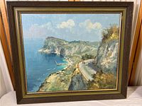 Full view of framed coastal road landscape painting showing cliffside, sea, sky, and road with small figures.