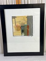 Framed abstract art print with geometric shapes and mixed colors, shown from front view.