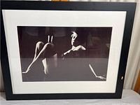 Full view of vintage black and white photographic print in black frame with white matting.