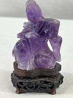 Front view of purple amethyst seated woman on carved wood stand