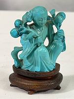 Front view of the turquoise carved figure on its stand