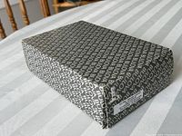 Original Bulova branded packaging box for the clock showing repetitive Bulova text pattern.