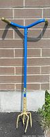 Full view of the 40-inch tall garden cultivator tool with blue handle and gold claw tines.
