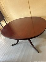 Oval mahogany dining table with smooth tabletop and rounded edges